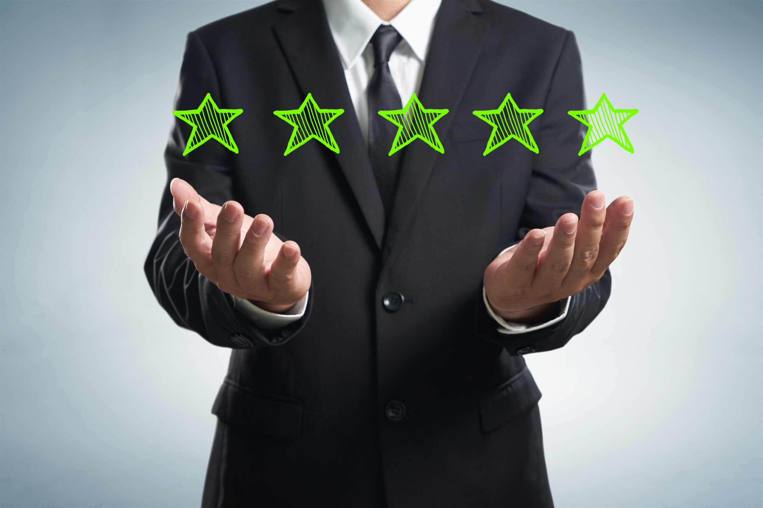 Businessman holding five star rating.